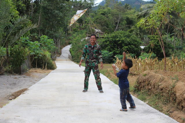 Senangnya Anak Kecil Bermain Layang Layang di Jalan Rata dan Bagus Karya TMMD ke 121 Selur